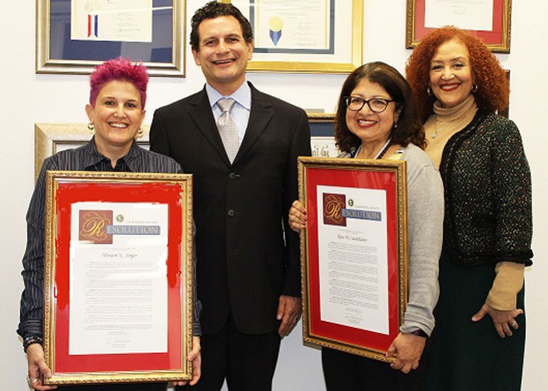 Paralegal Miriam Singer and Senior Paralegal Rose Castellanos hold up their State Senate resolutions, with Public Defender Ricardo García and Supervising Paralegal Rhonda Cameron.