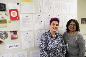 Miriam Singer and Rose Castellanos stand in front of their “wall of pardons.”