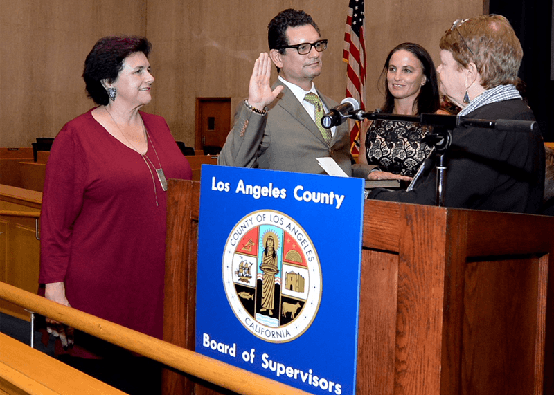 Ricardo Garcia having his hand up swearing in to become public defender.